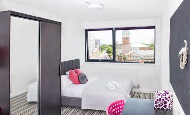 Inside the a Bath Room bedroom features a double bed, large window and wardrobe