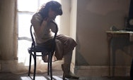 Actress sitting on a chair by a window