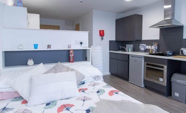 Studio inside Oxford Point featuring a bed and kitchen