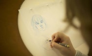 Student using a lightbox to draw a women