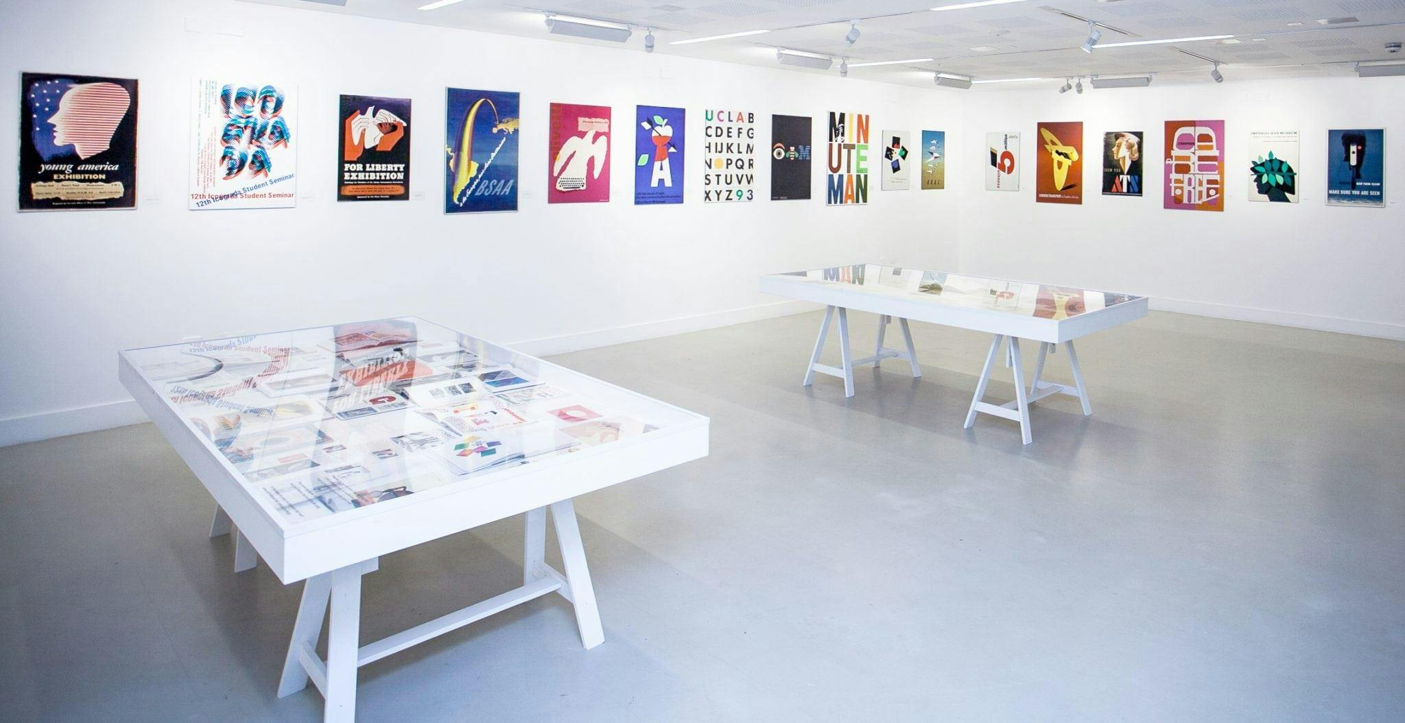 Colourful posters displayed on TheGallery's walls with two tables in the middle of the room.