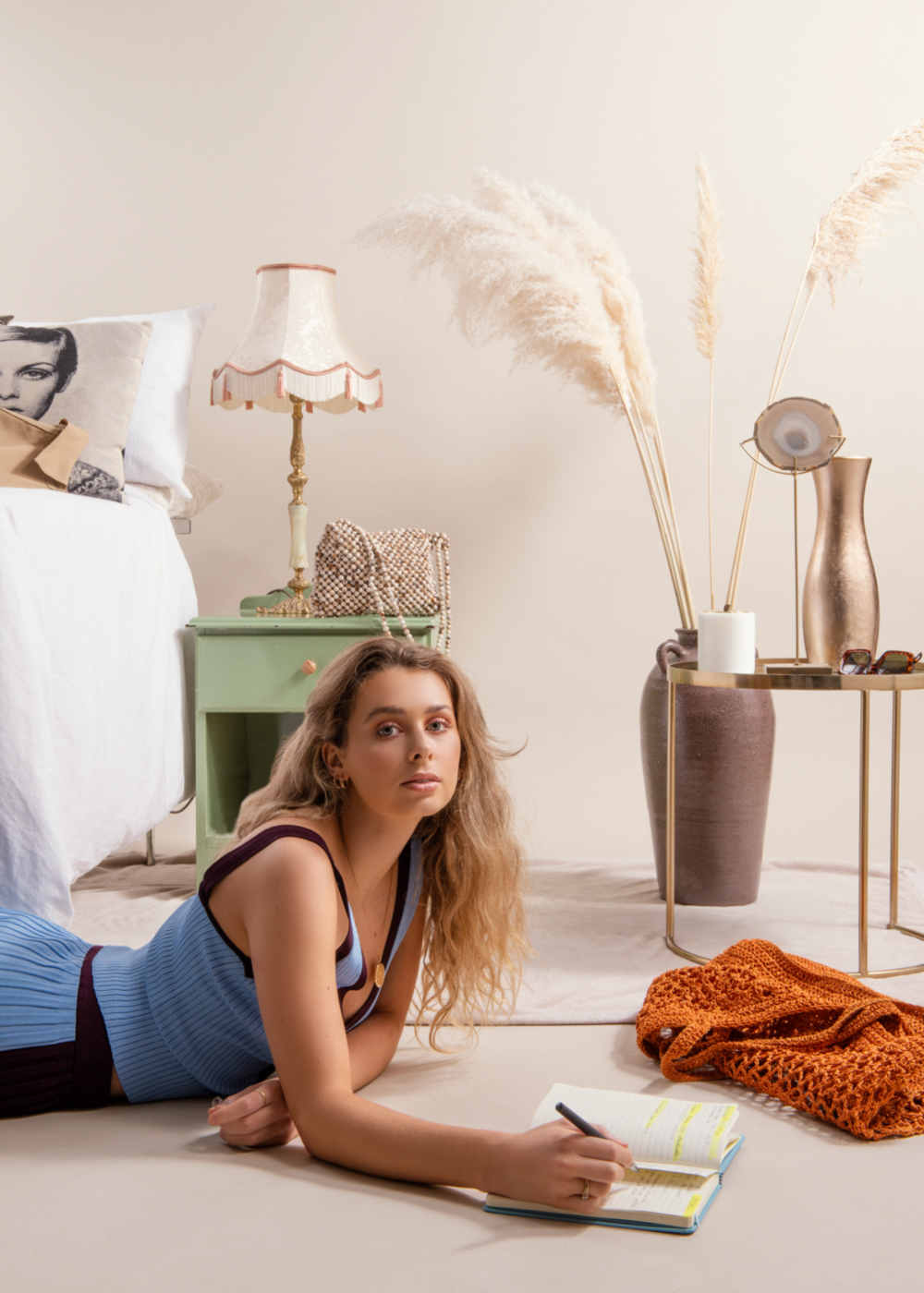 Lifestyle advertising with woman writing on the floor in a bedroom.