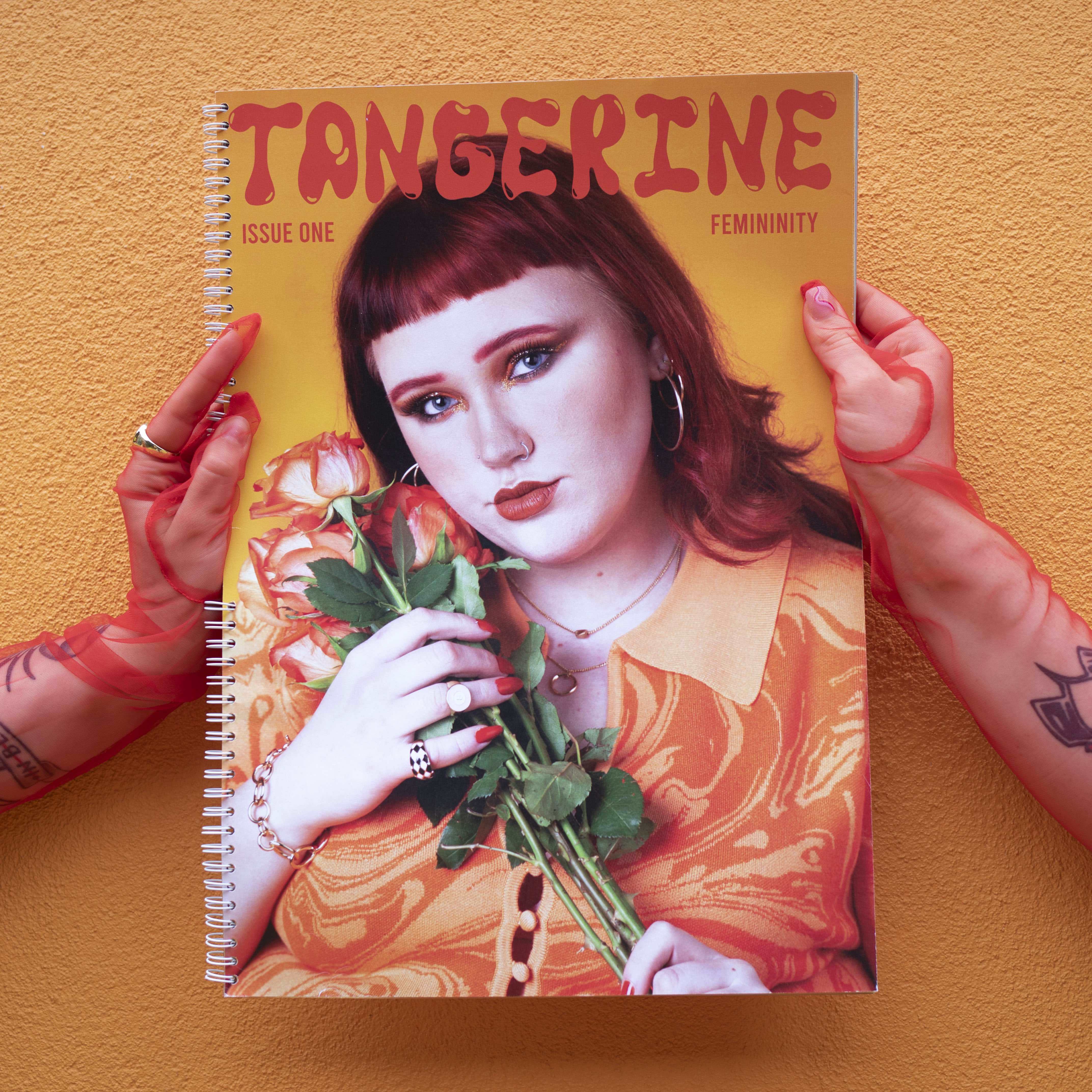 'Tangerine' magazine cover, red gloved hands holding magazine in front of orange background