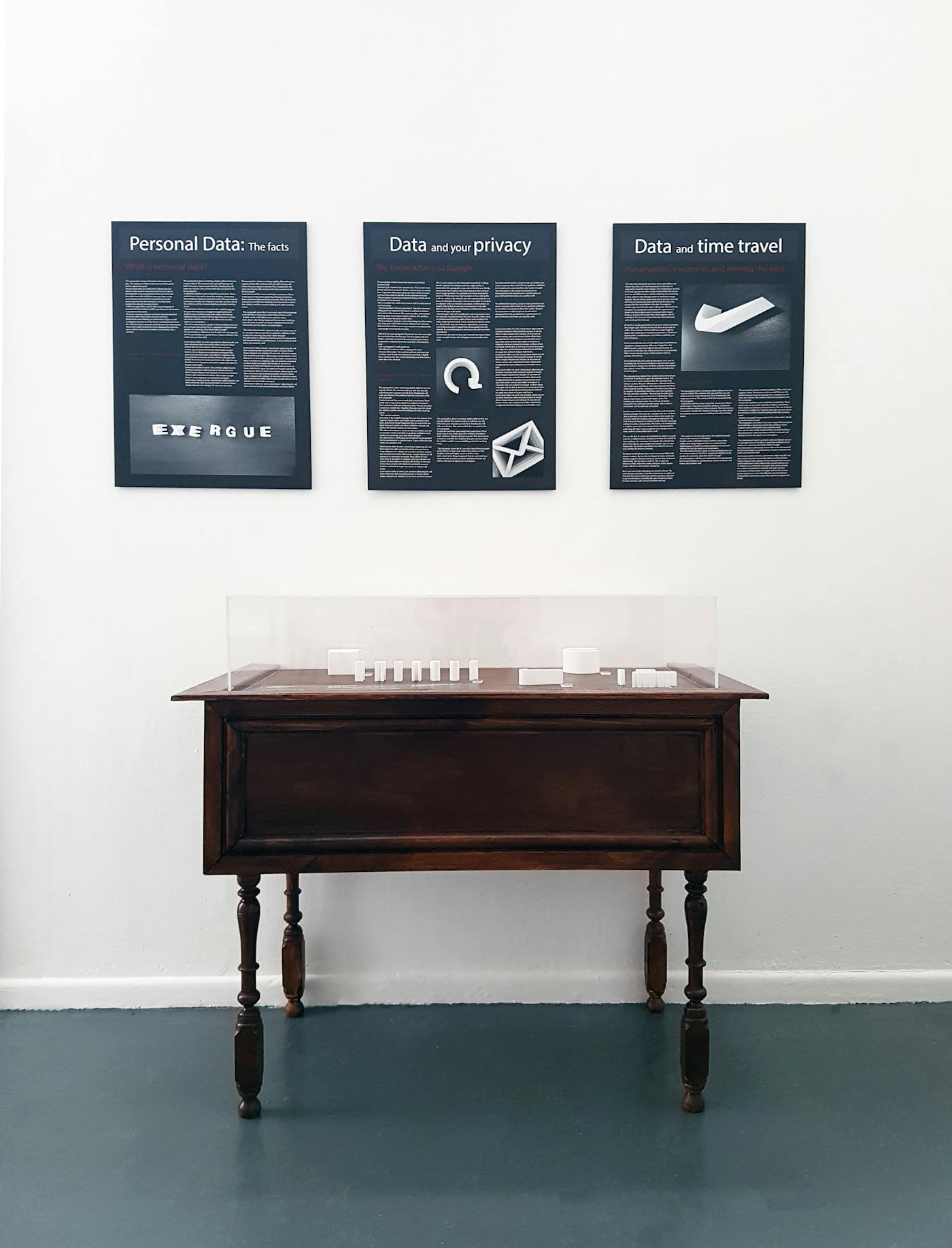 A table against a white wall with three infomative posters
