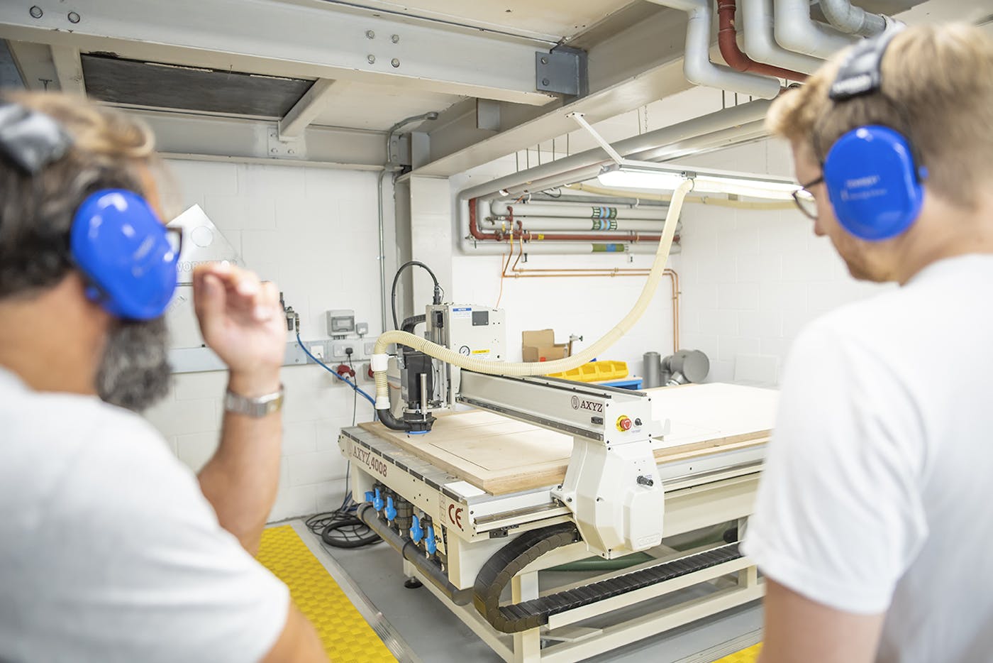 Two people looking at a CNC router