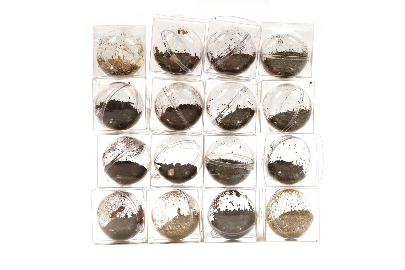 Twelve clear balls filled with different coloured soil