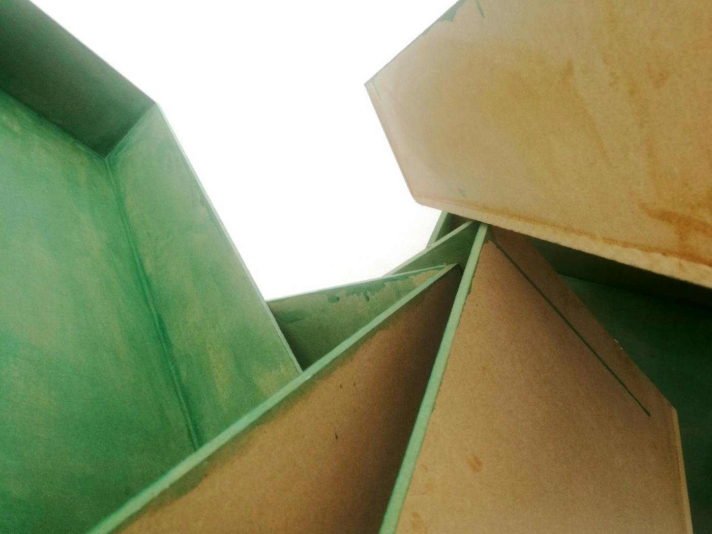 Worm eye view of multiple canvases painted green leaning against each other