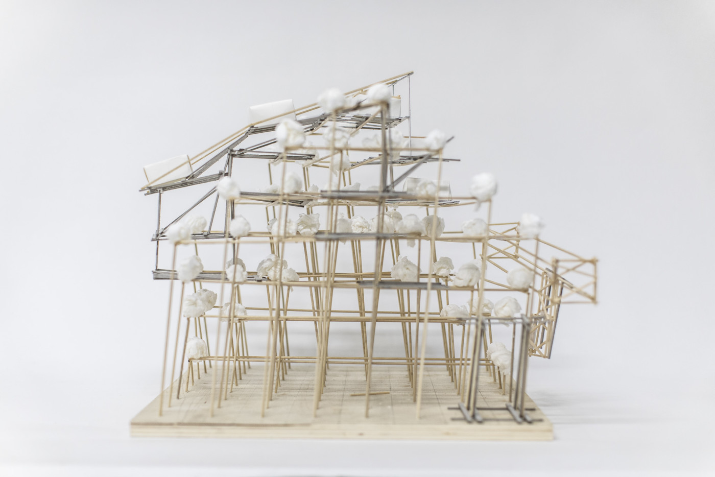Architectural model created with thin, long wooden sticks and cotton balls.