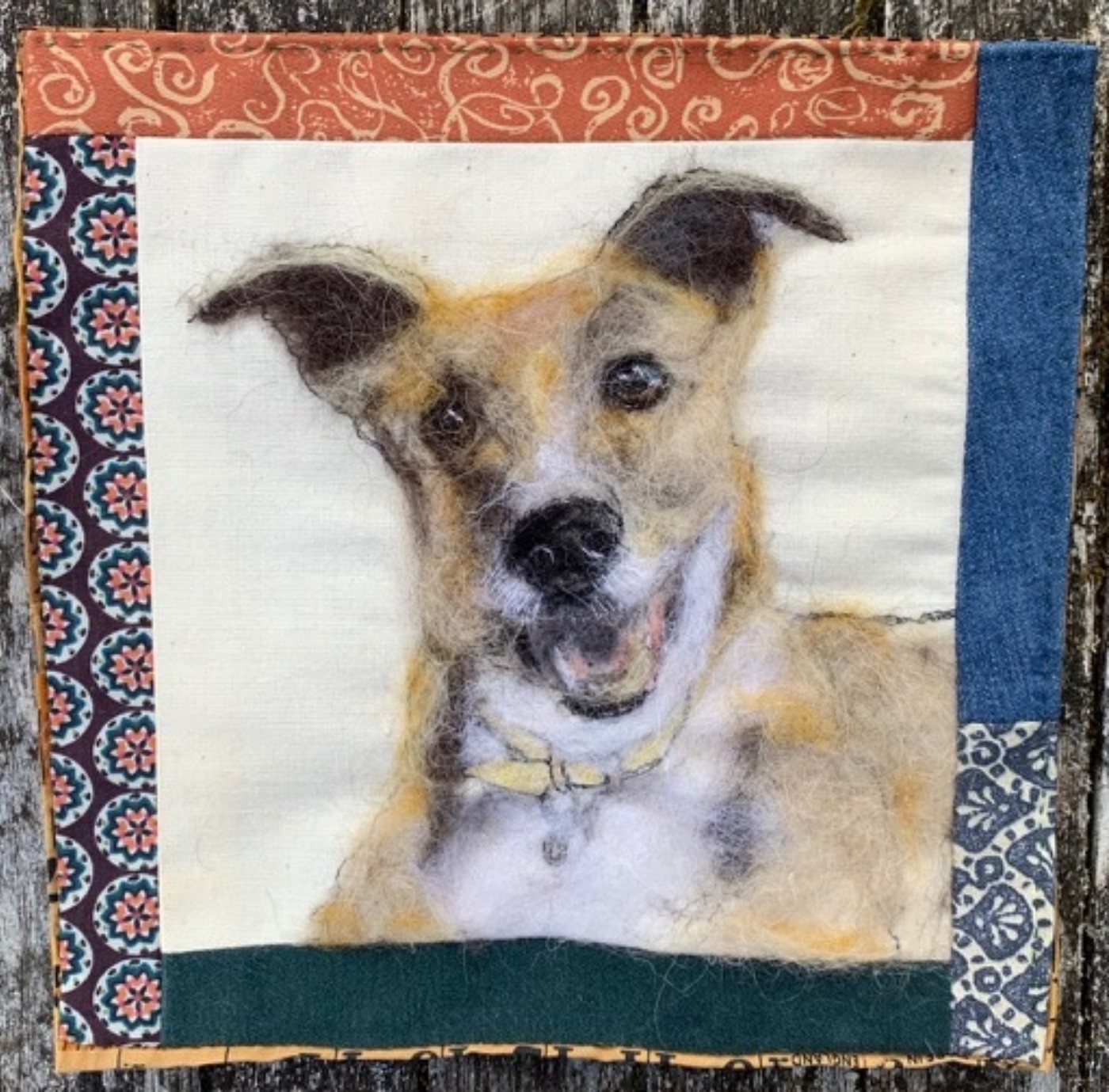 Painting of a dog with a border made from different coloured and patterned fabric