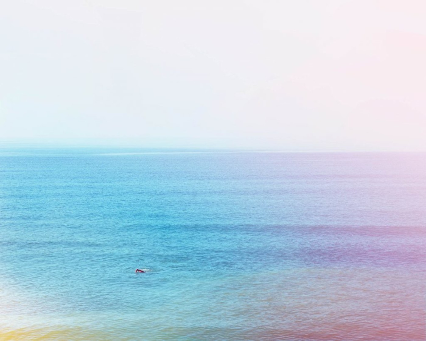 Photograph of a person swimming in the ocean with light burns