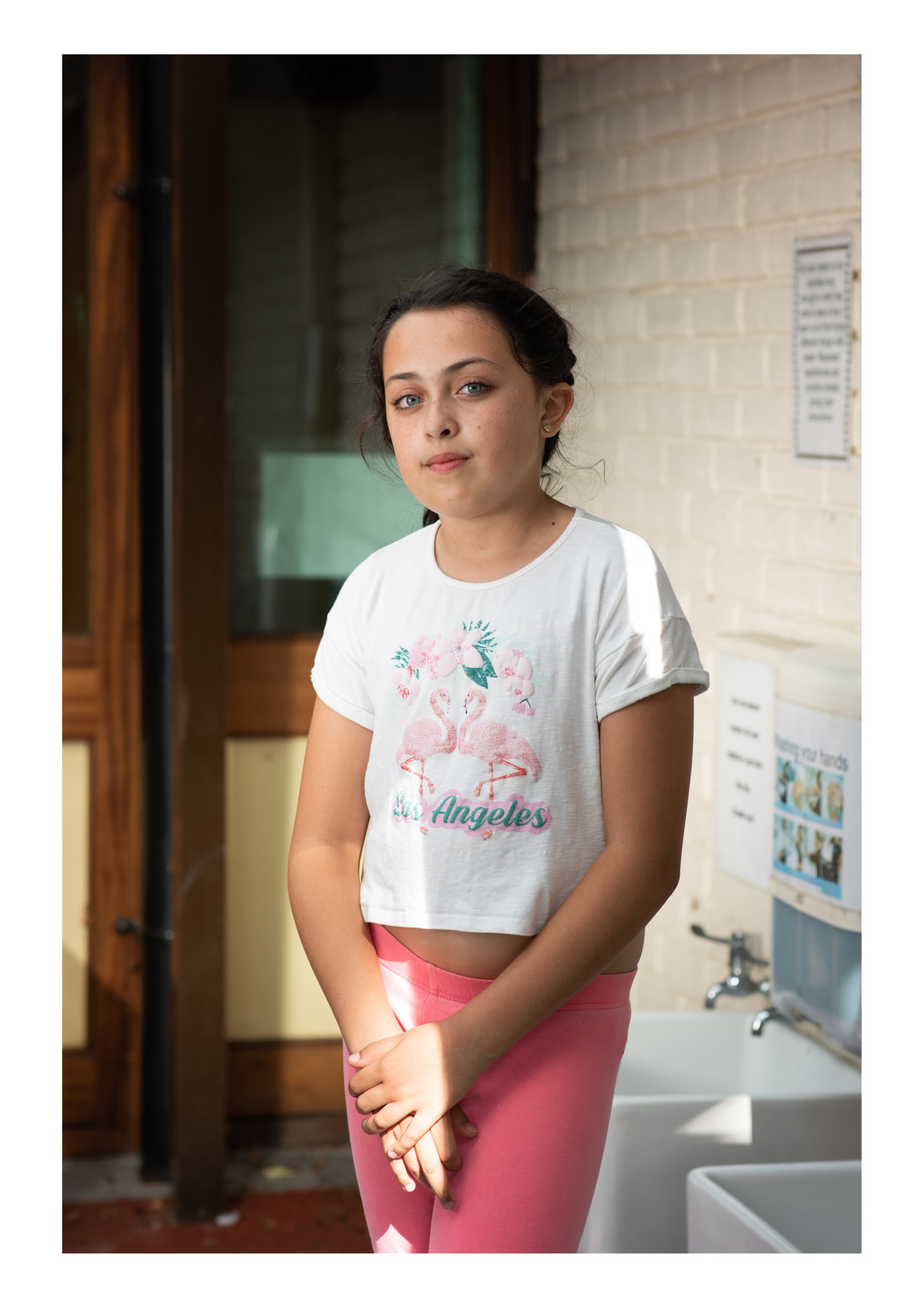 Photography of a girl wearing a graphic shirt and pink trousers