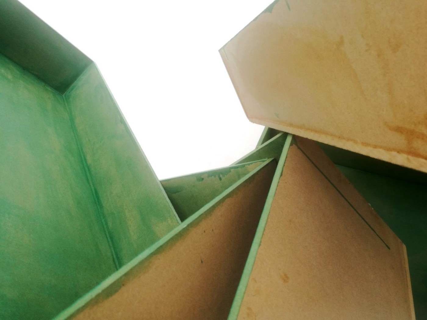 Worm eye view of multiple canvases painted green leaning against each other