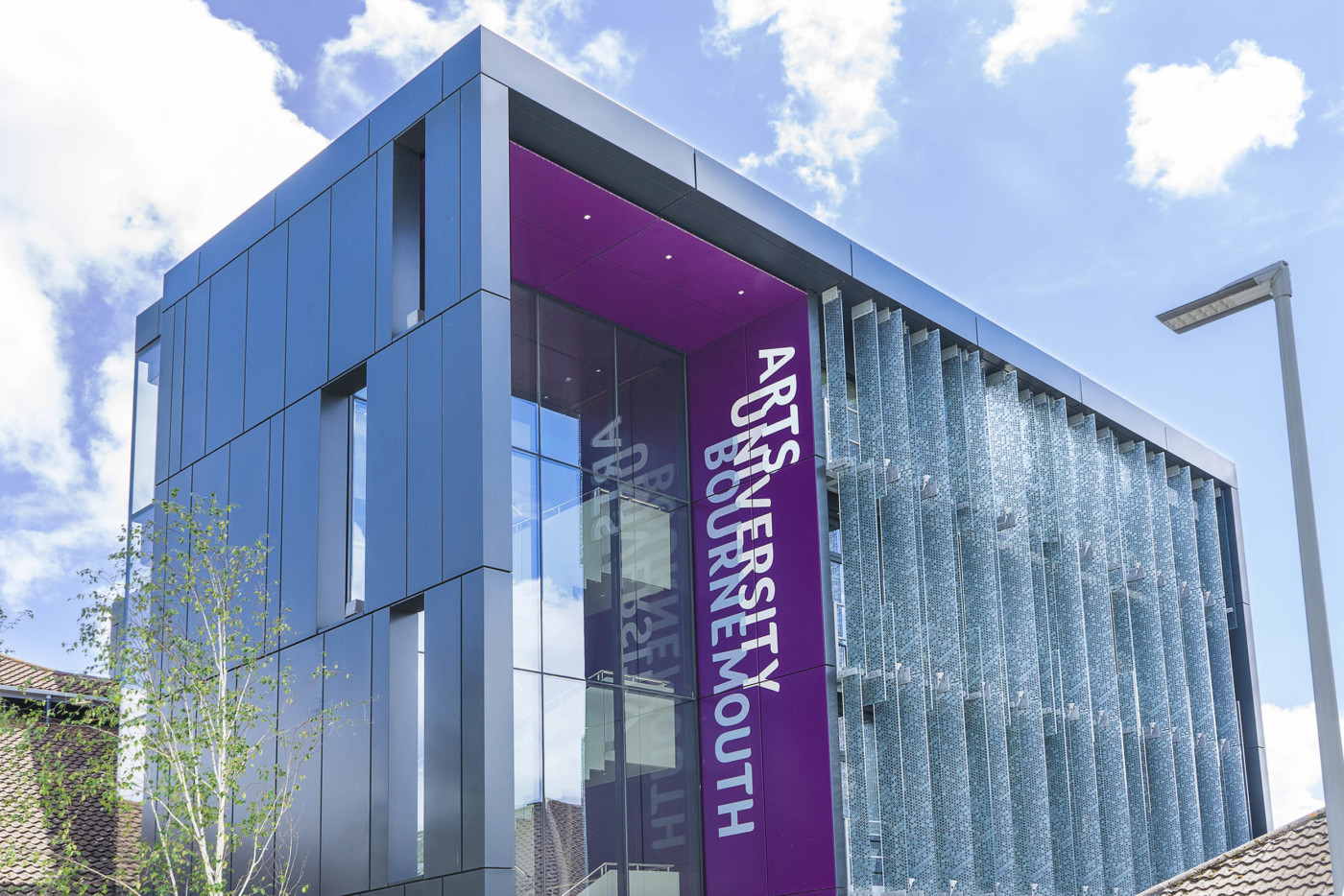 A building with four floors, and lots of windows. There's a purple panel that reads: Arts University Bournemouth