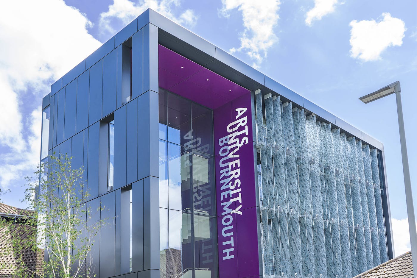 A building with four floors, and lots of windows. There's a purple panel that reads: Arts University Bournemouth