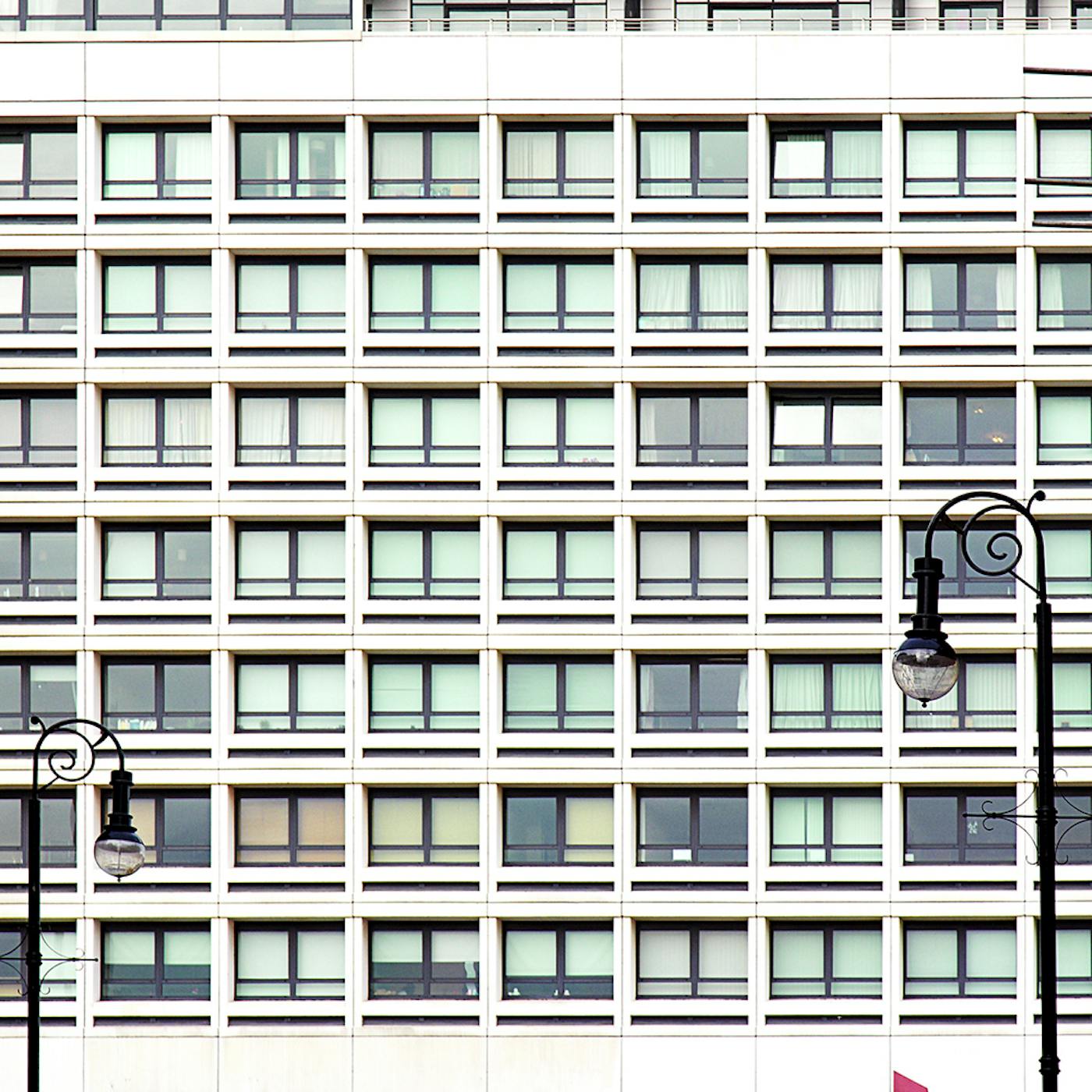 Close crop of an apartment block featuring two lampposts