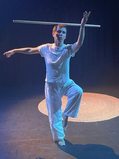 A dancer strikes a pose with arms outstretched and a leg raised